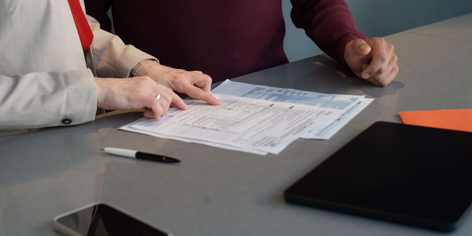 Two people reviewing documents at a table.